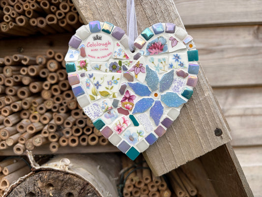 Handcrafted mosaic heart hanging made from vintage Colclough bone china with pink and blue florals, teal and lilac tile border, iridescent blue centrepiece and white ribbon loop