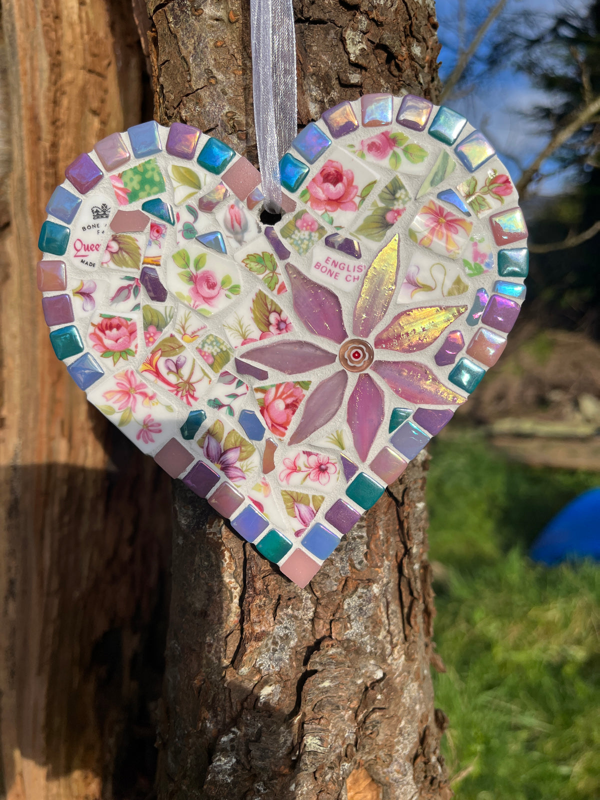Close-up of Queen's bone china rose mosaic heart showing iridescent tile border and purple glass flower centrepiece